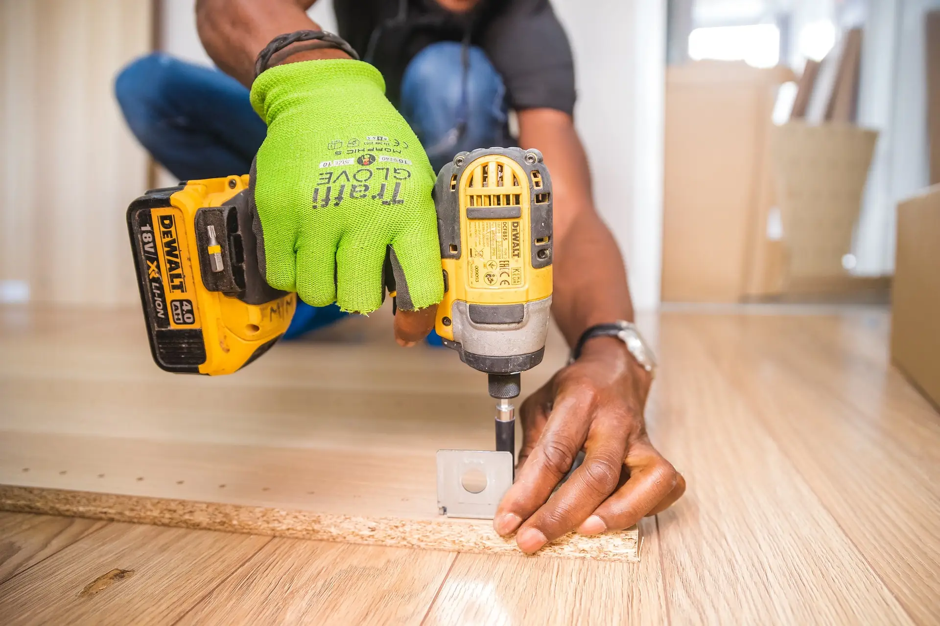 Handyman using a power drill on a wooden floor